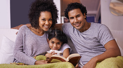 Buy stock photo Family, child and reading book portrait in a home for story time on a lounge sofa with a smile. A woman, man or parents and girl child together for development, learning and love with a fantasy