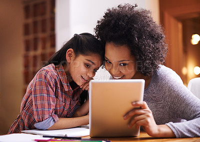Buy stock photo Shot of a mother helping her daughter with her homework using a tablet