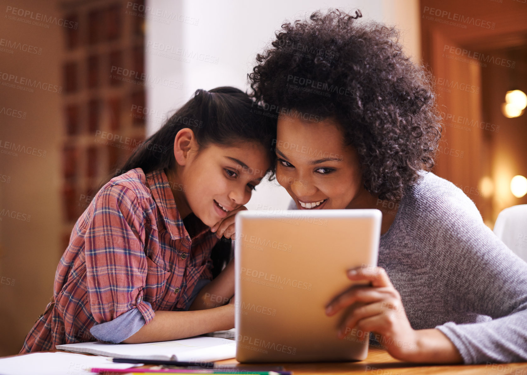 Buy stock photo Shot of a mother helping her daughter with her homework using a tablet