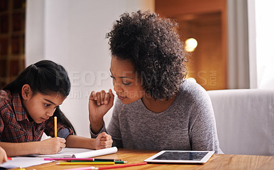 Buy stock photo Shot of a mother helping her daughter with her homework