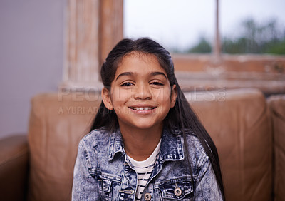 Buy stock photo Smile, portrait and girl child on sofa in living room with positive, good and confident attitude. Happy, sweet and face of cute young kid sitting on couch for relaxing in lounge at modern home.