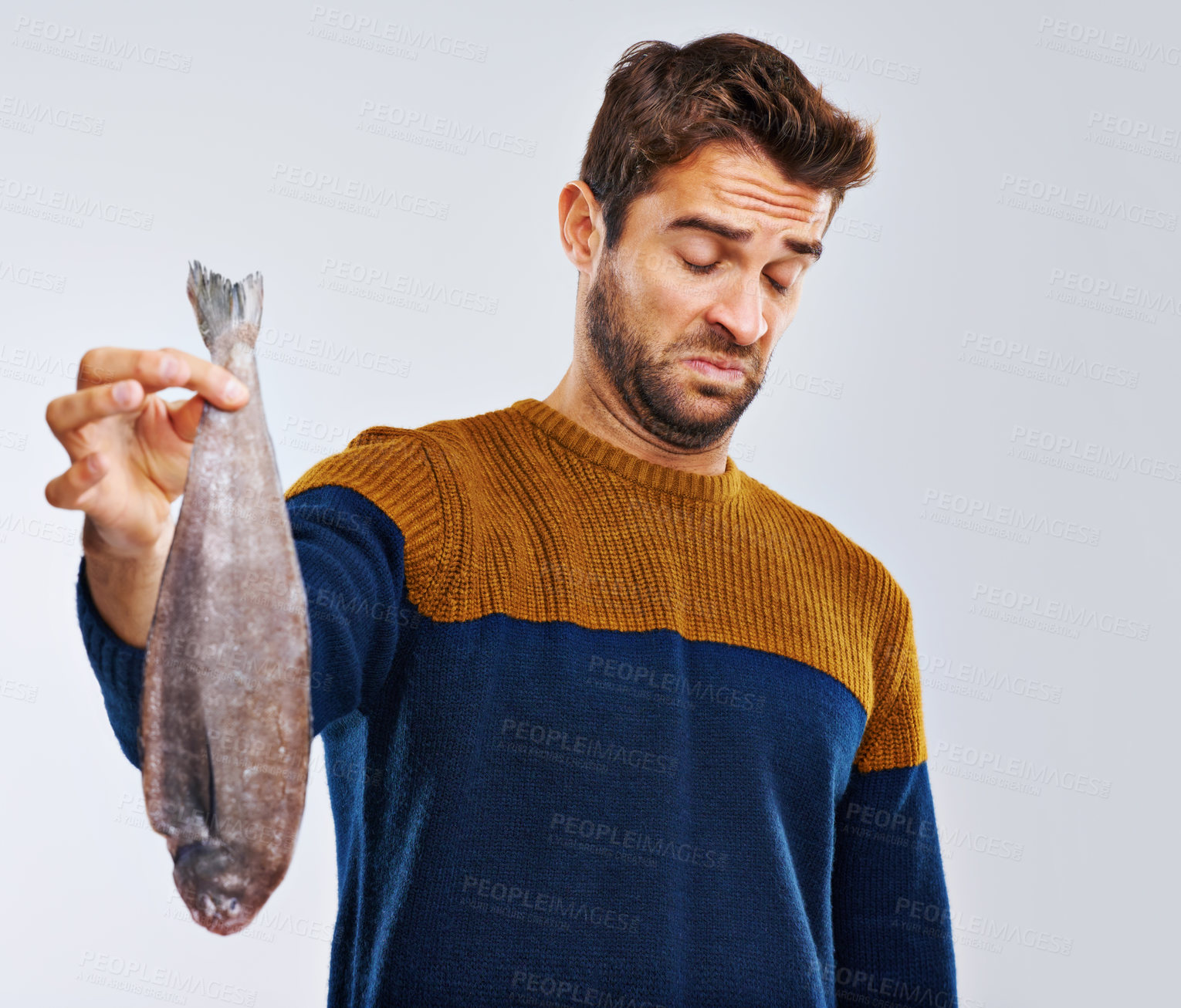 Buy stock photo Man, disgust and fish with bad odor, smell or stench of animal or sea creature on a gray studio background. Male person with gross facial expression of disgusted aroma or smelly odd stink on mockup