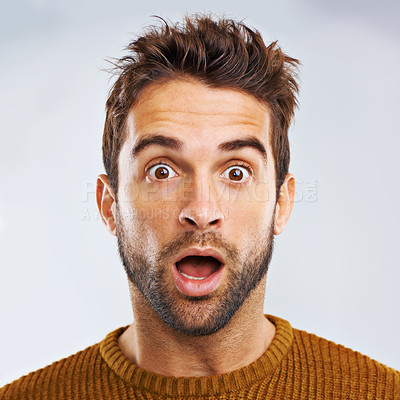 Buy stock photo Portrait of a shocked young man against a gray background