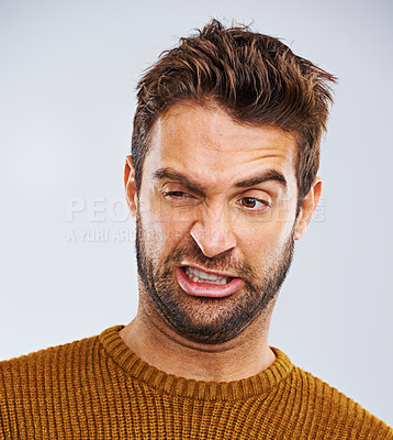 Buy stock photo Man, face and grimace with disgust in studio for dirty hygiene, smelling odor and negative body language. Person, shame and regret on white background for halitosis problem and upset expression