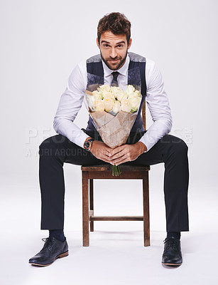 Buy stock photo Studio, portrait and man with chair, bouquet and date for style and fashion. Gentleman, designer and romance with flowers, confidence and proud ambition with suit isolated on white background