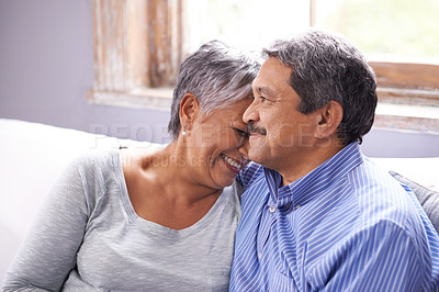 Buy stock photo Happy, love and elderly couple on sofa with laugh for funny conversation, bonding and embrace at home. Retirement, relax and senior people with smile for joke, satisfaction and support in living room