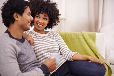 Buy stock photo Cropped shot of an affectionate young couple relaxing together on a sofa at home