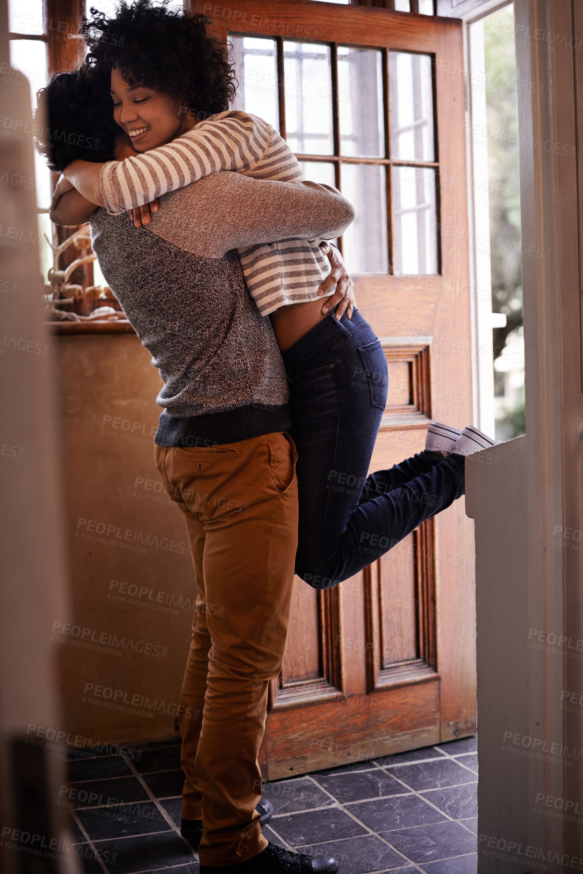 Buy stock photo Cropped shot of a young woman greeting her husband at the door