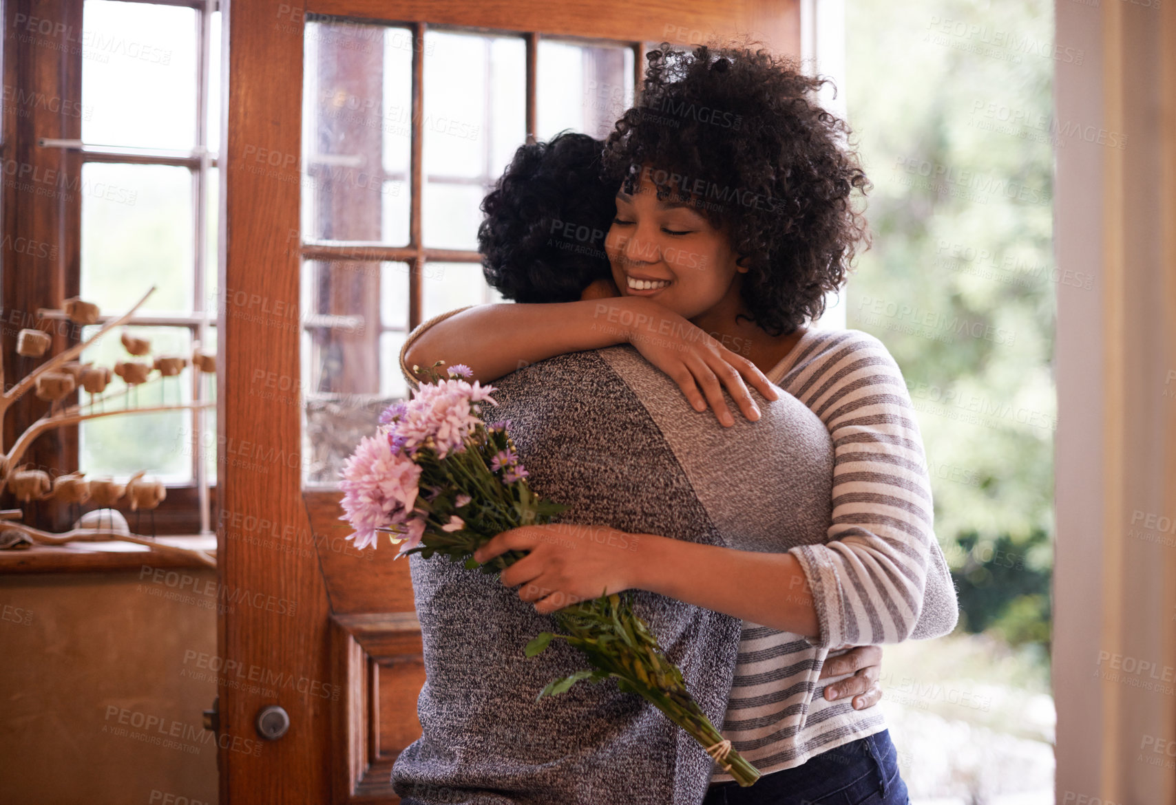 Buy stock photo Cropped shot of an affectionate young couple hugging in the doorway