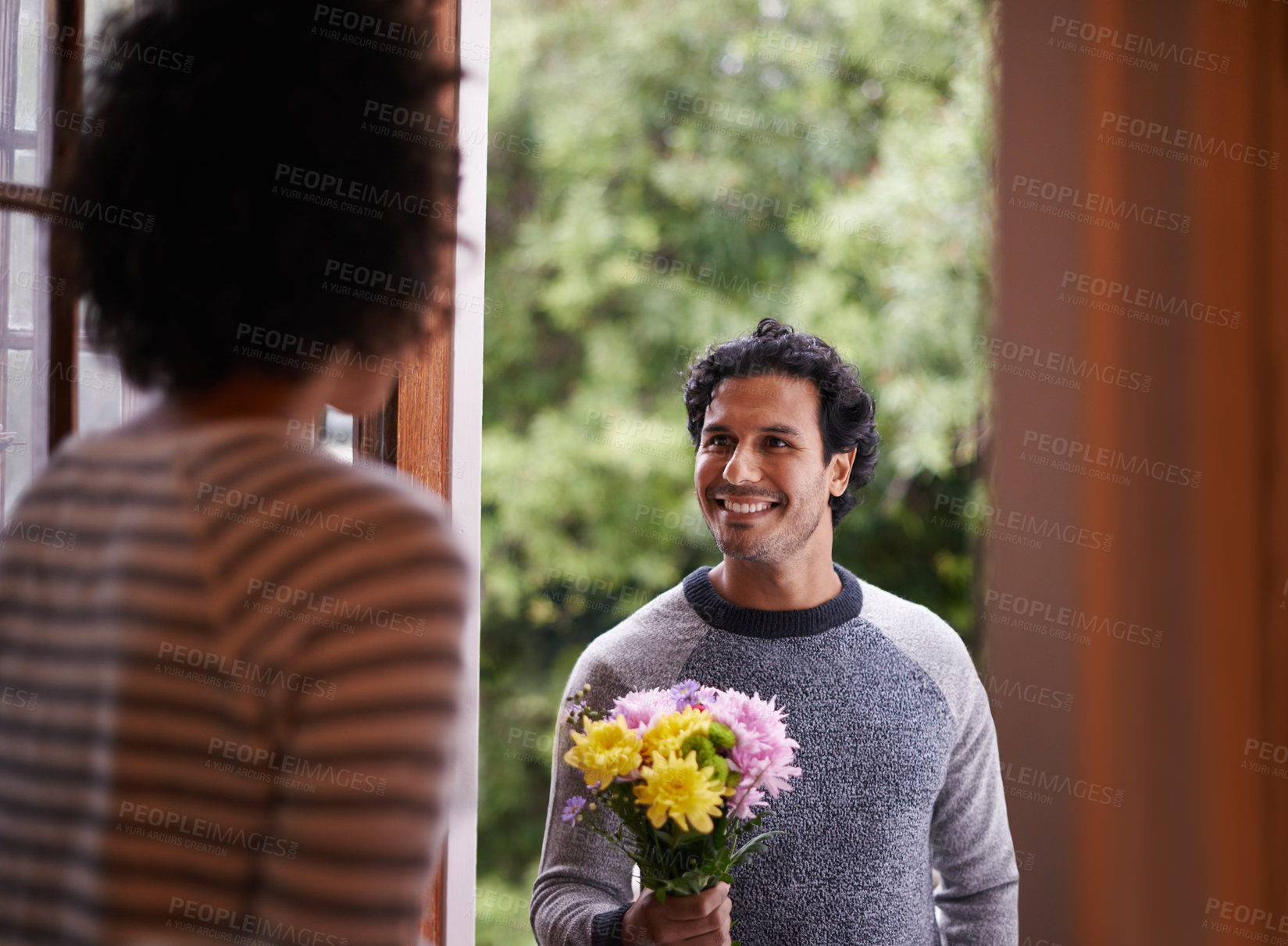Buy stock photo Cropped shot of a young man surprising his wife with flowers
