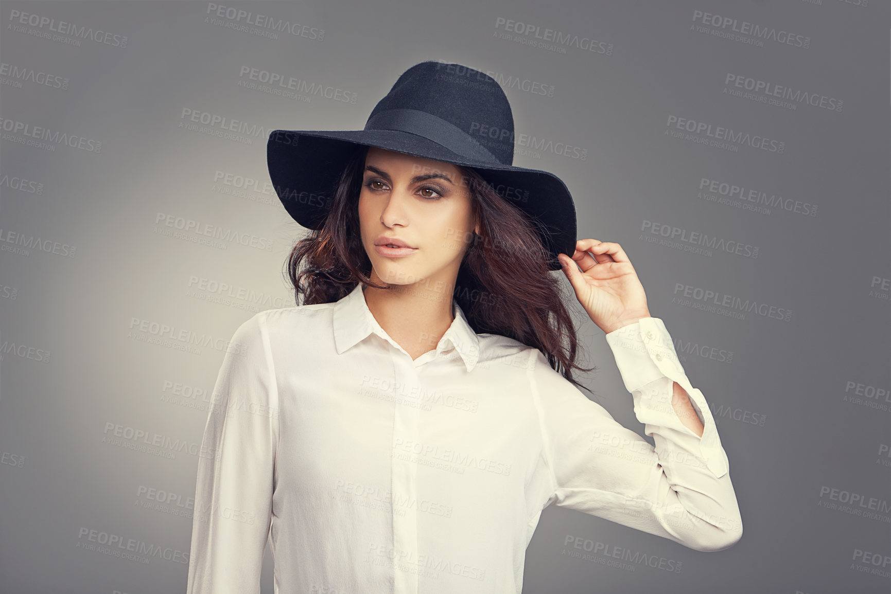 Buy stock photo Fashion, thinking and young woman in studio with classy, trendy and stylish hat for outfit. Confident, makeup and female person with ideas for elegant style and accessory isolated by gray background.