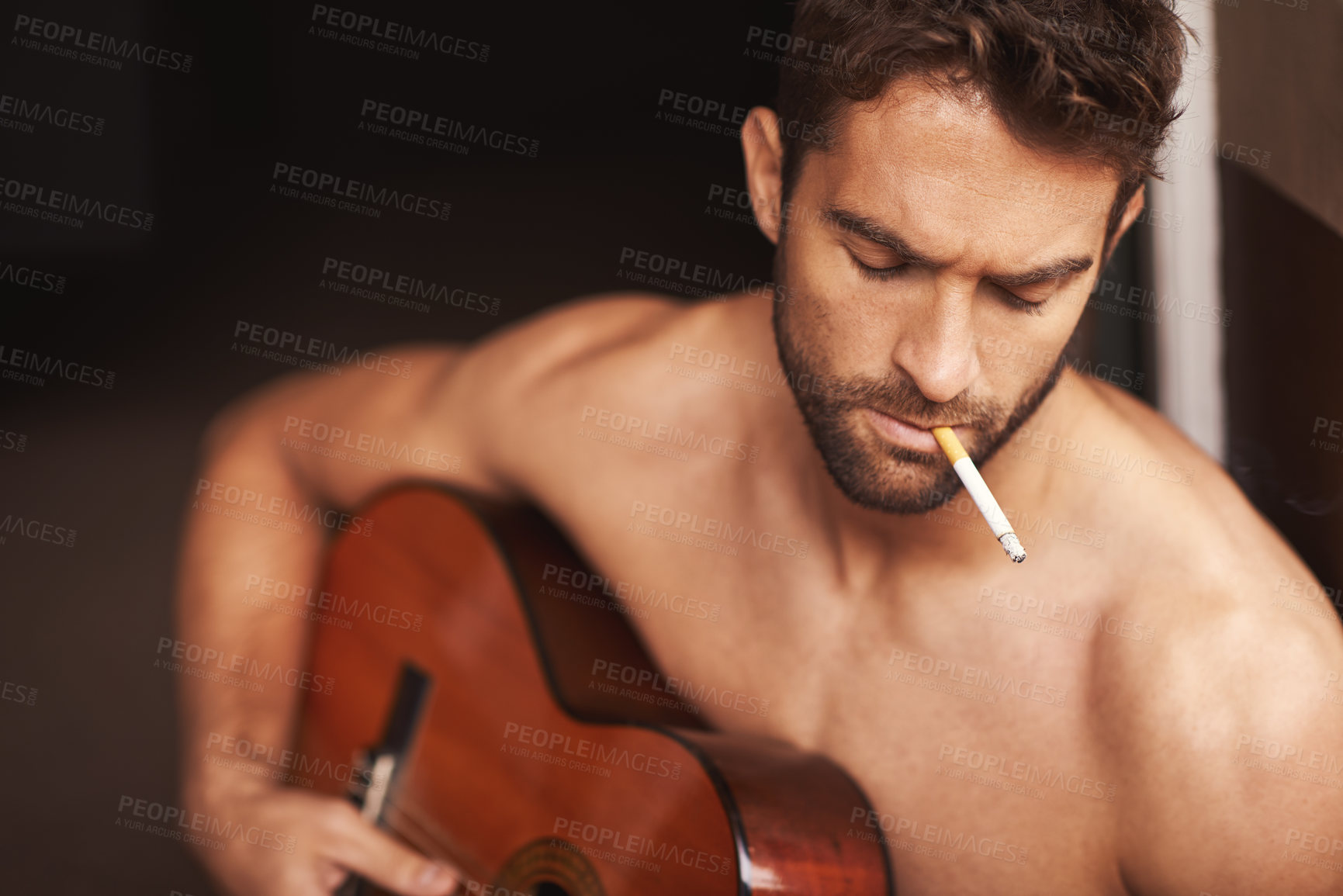 Buy stock photo Cropped shot of a shirtless young man playing guitar at home