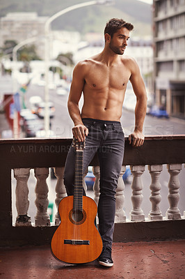 Buy stock photo Cropped shot of a shirtless young man with his guitar