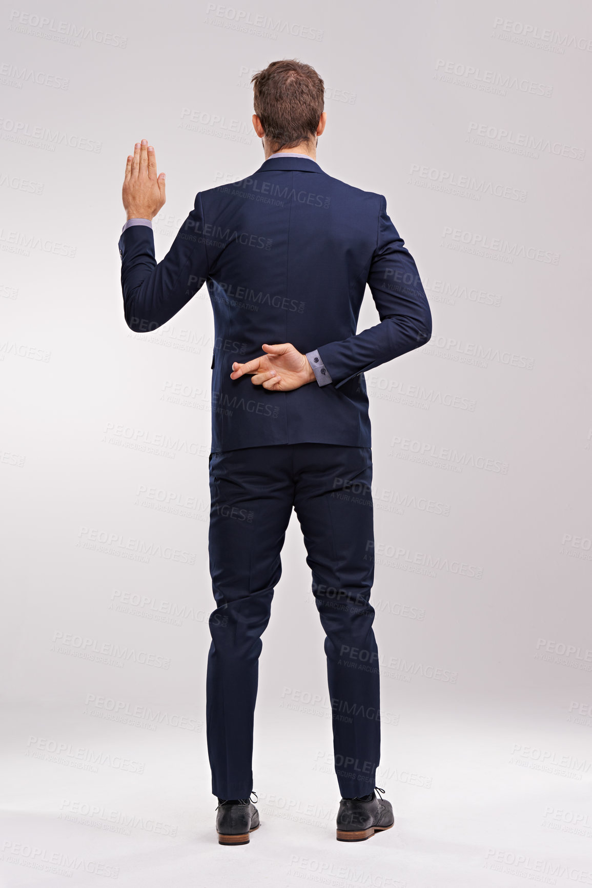 Buy stock photo Back of businessman, taking an oath and fingers crossed in a white background. Legal or court, cheat or corruption and dishonest man or liar with suit in studio backdrop with hand gesture for a lie