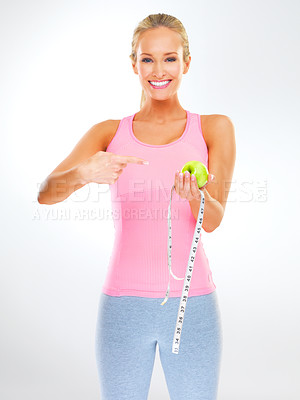 Buy stock photo Woman, portrait and apple with measuring tape for healthy weight loss or hungry, wellness or white background. Female person, face and pointing at fruit in studio or training routine, diet or mockup