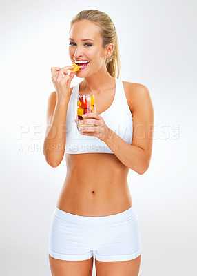 Buy stock photo Fitness, eating and face of woman with fruit in glass for nutrition, healthy diet and salad isolated on white background. Female person, body and wellness coach with gym clothes for workout in studio
