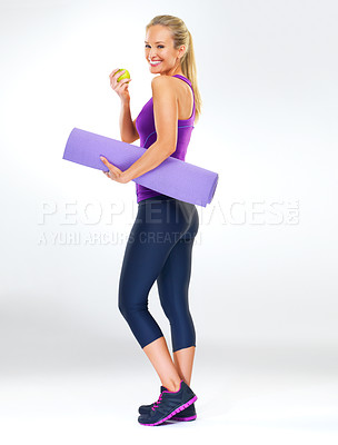 Buy stock photo Woman, portrait and fitness in studio with apple for healthy body, nutrition and wellness with yoga mat. Pilates, person and smile with fruit to lose weight or natural antioxidant on white background