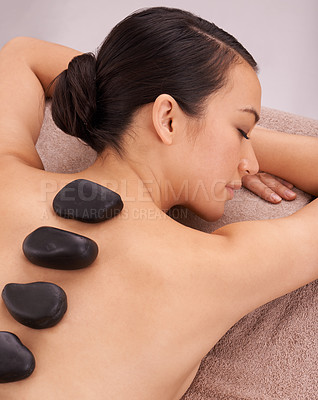 Buy stock photo Wellness, woman and massage with hot stone therapy and skin detox with vacation and stress relief. Natural, person or girl with peace or calm with holiday or weekend break with luxury resort or relax
