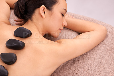 Buy stock photo Relax, woman and massage with hot stone therapy and wellness with weekend break and stress relief. Natural, person and girl with peace or spa with holiday and rocks with skin detox or luxury resort