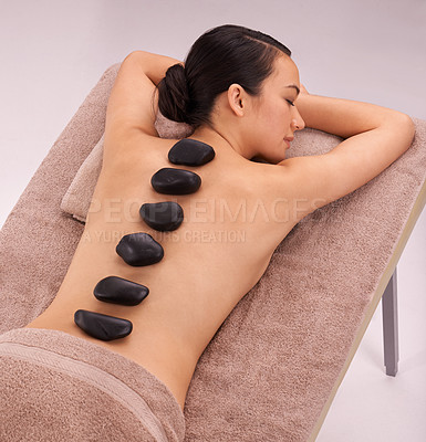 Buy stock photo Peace, woman and massage with hot stone therapy and wellness with vacation, relax or rocks. Natural, person or girl with stress relief or calm with holiday or healing with skin detox or luxury resort