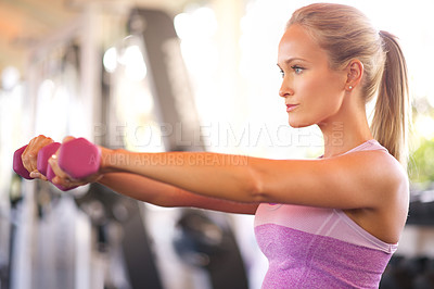 Buy stock photo Shot of a young woman lifting weights