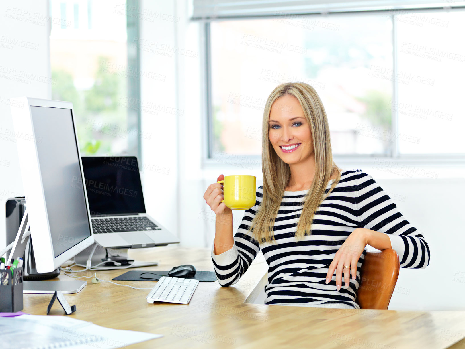 Buy stock photo Shot of a beautiful young woman working at her office desk while enjoying a drink