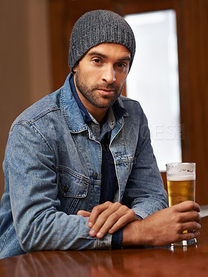 Buy stock photo Portrait, beer and male person thinking at pub, drinks and restaurant for entertainment. Pensive, alcohol and bar for thoughtful or social for relax, smile and beanie for cold weather in England  