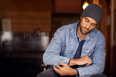 Buy stock photo Man, trendy and winter fashion in home, house and hipster with serious male person sitting in warm clothes. Beanie, head wear for comfort, indoor and fixing denim jacket for urban trends in Canada