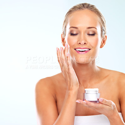 Buy stock photo Woman, smile or face cream for skincare or wellness with cosmetics, aesthetic mockup or glow in studio. Dermatology, happy or confident model with space, shine or beauty lotion on blue background
