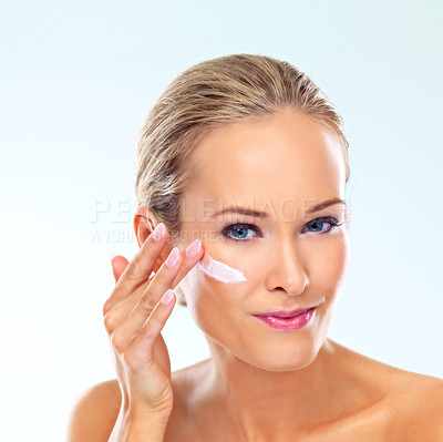 Buy stock photo Woman, skincare and portrait with cream on face for cosmetics, dermatology, and self care in studio. Female person, confidence and product with lotion, moisturizer and application on blue background