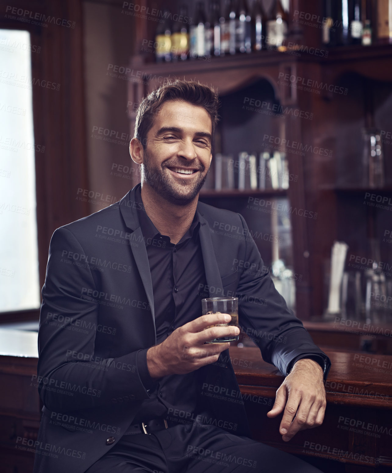 Buy stock photo Businessman, happy portrait or alcohol for break in hotel or drink to relax on startup project. Young person, indoor or face for whisky by counter for leisure or friendly as hospitality professional