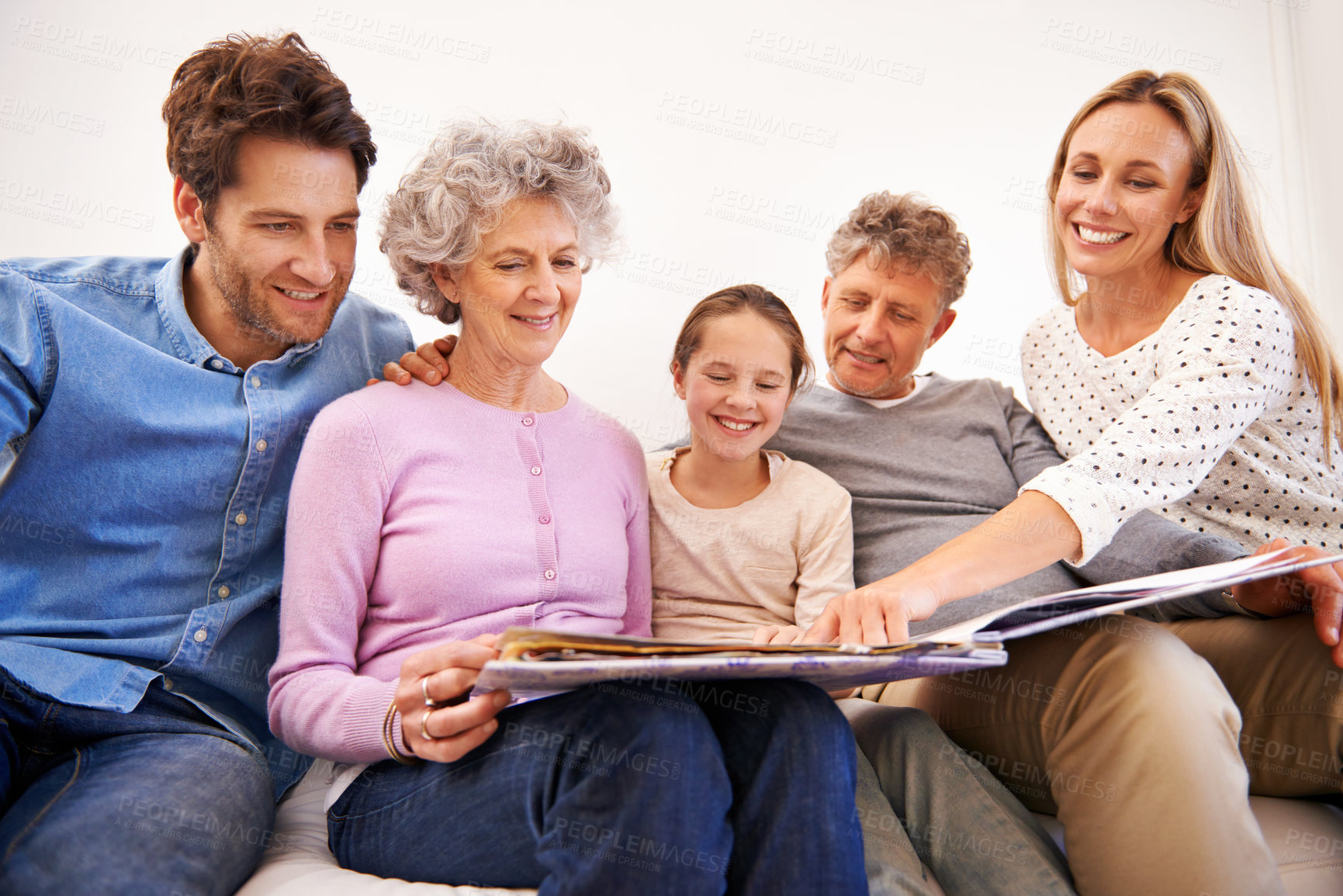 Buy stock photo Shot of a happy multi generation family looking through a photo album together