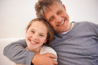 Buy stock photo Portrait of a granddaughter and her grandpa sitting at home