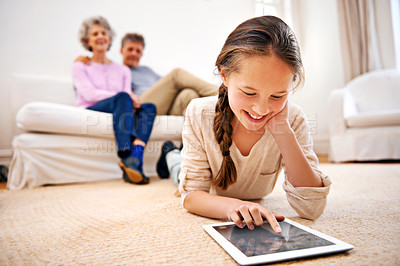 Buy stock photo Relax, kid or girl with tablet for elearning or studying for remote education on carpet at home. Family, grandfather or grandmother with a happy child reading ebook or streaming video or movie