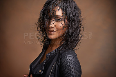 Buy stock photo Fashion, portrait and leather jacket with woman, aesthetic and stylish clothes on brown studio background. Face, Indian person and model with mockup space and happy girl with bold and cool makeup