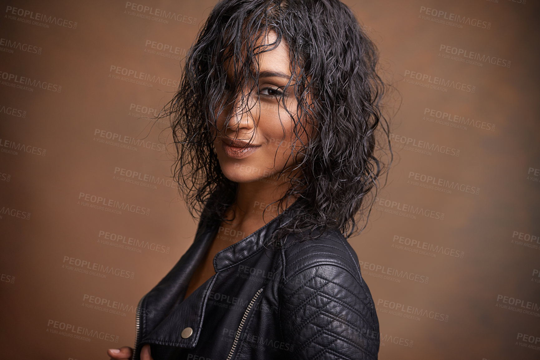 Buy stock photo Fashion, portrait and leather jacket with woman, aesthetic and stylish clothes on brown studio background. Face, Indian person and model with mockup space and happy girl with bold and cool makeup