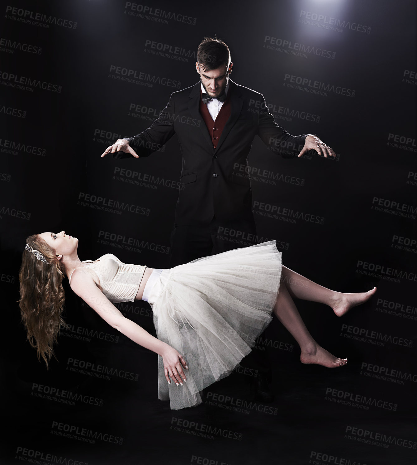 Buy stock photo Shot of vaudeville magician levitating a woman on stage