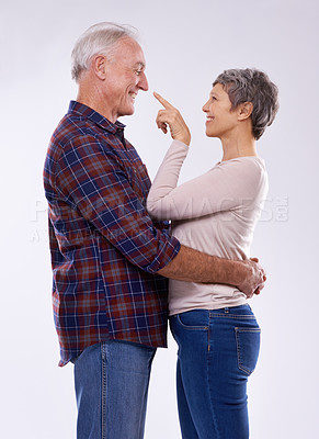 Buy stock photo Senior, couple and happy hug in studio together, smile and retired people in elderly love relationship. Pointing, female person with man on white background, affection on mockup space with joy