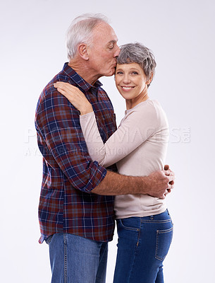 Buy stock photo Portrait, kiss and senior couple on a white background for bonding, affection and happy relationship. Marriage, love and mature man and woman embrace for commitment, trust and care in studio together