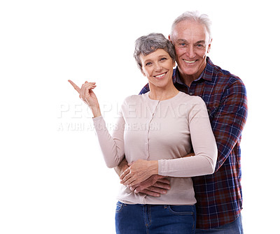 Buy stock photo Happy, pointing and senior couple in studio, hug together or  customer loving relationship for retired people. Information, advertising or presentation on background, promotion show on mockup space