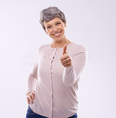 Buy stock photo Studio portrait of an mature woman giving thumbs up against a white background