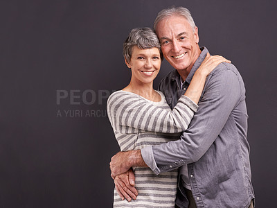 Buy stock photo Portrait, hug and old couple with love, smile and relationship on a grey studio background. Retirement, happiness or senior man with mature woman or embrace with romance, marriage or bonding together