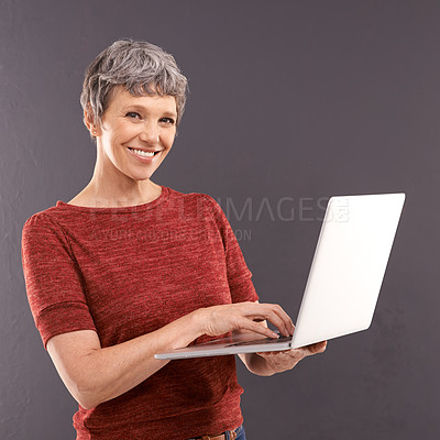 Buy stock photo Senior, woman and laptop in studio with smile, technology and online search or typing and internet connection. Information, browse or social networking, elderly female person on mockup background