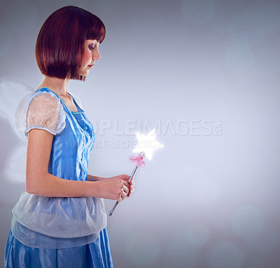 Buy stock photo Whimsical, fairy and woman with wand of magic and lighting for fantasy in grey background. Adult, female person and girl with butterfly wings, dress and model with joy and mystical in studio