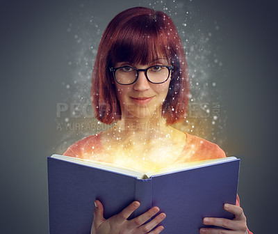 Buy stock photo A cropped shot of a young adult reading a book with glowing pages