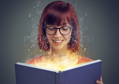 Buy stock photo Glowing pages, book and woman with a story, fantasy and education on grey studio background. Person, reader and girl with a novel and literature with knowledge or creativity with glasses or astrology