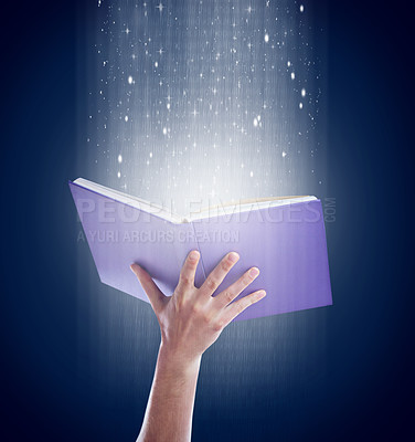 Buy stock photo Shot of a hand holding an open storybook with light emanating from it