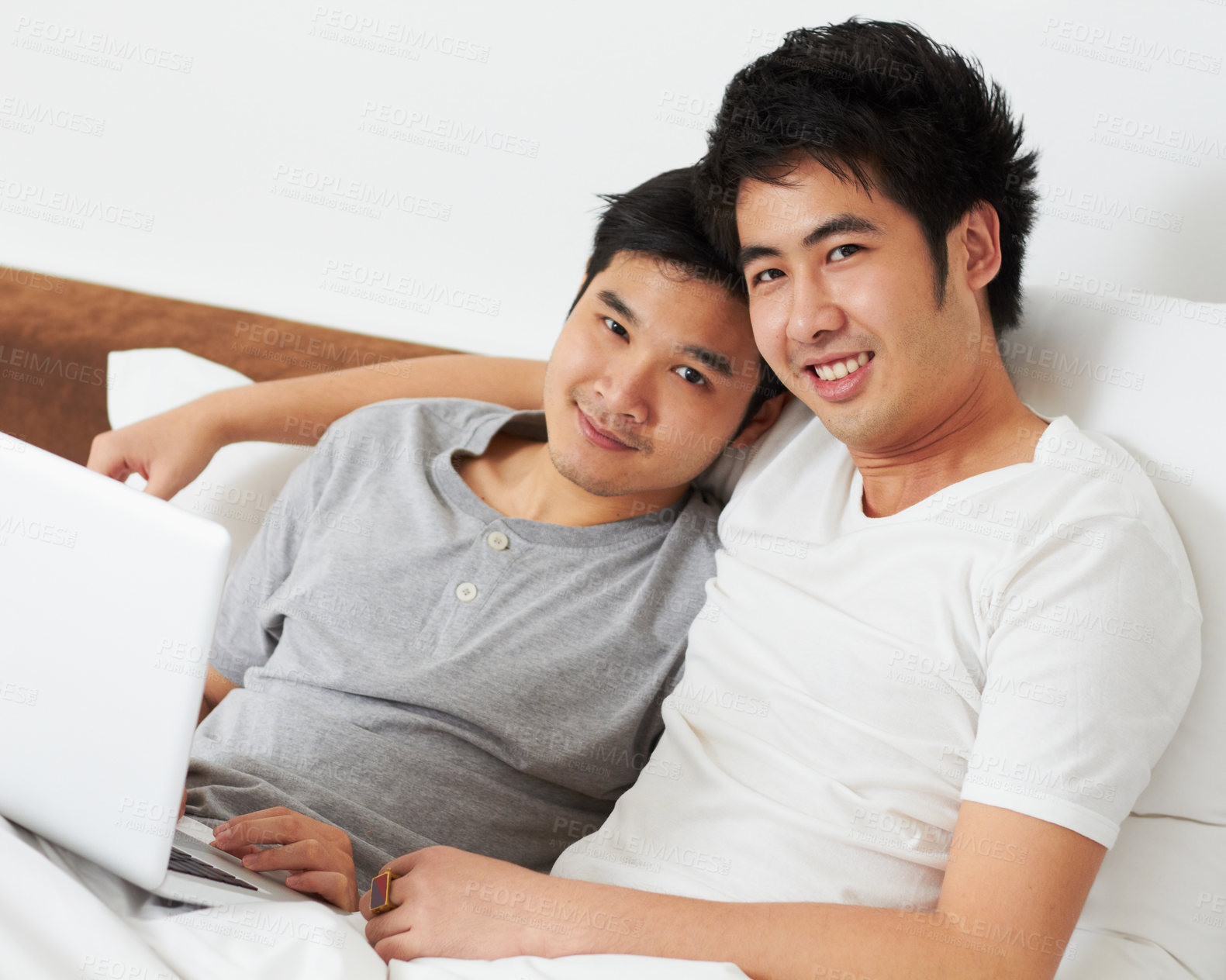 Buy stock photo Portrait, laptop and bed with a gay couple watching a movie together while bonding in the morning. Love, happy or smile with an lgbt man and partner lying in their bedroom to relax while streaming