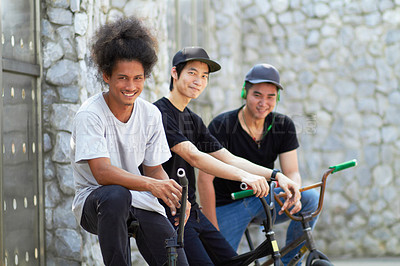 Buy stock photo A group of young bmx riders relaxing together