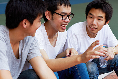 Buy stock photo Smile, talking and a group of asian friends sitting outdoor on university campus as scholarship students. Funny, conversation or bonding with happy young men outside together during college break